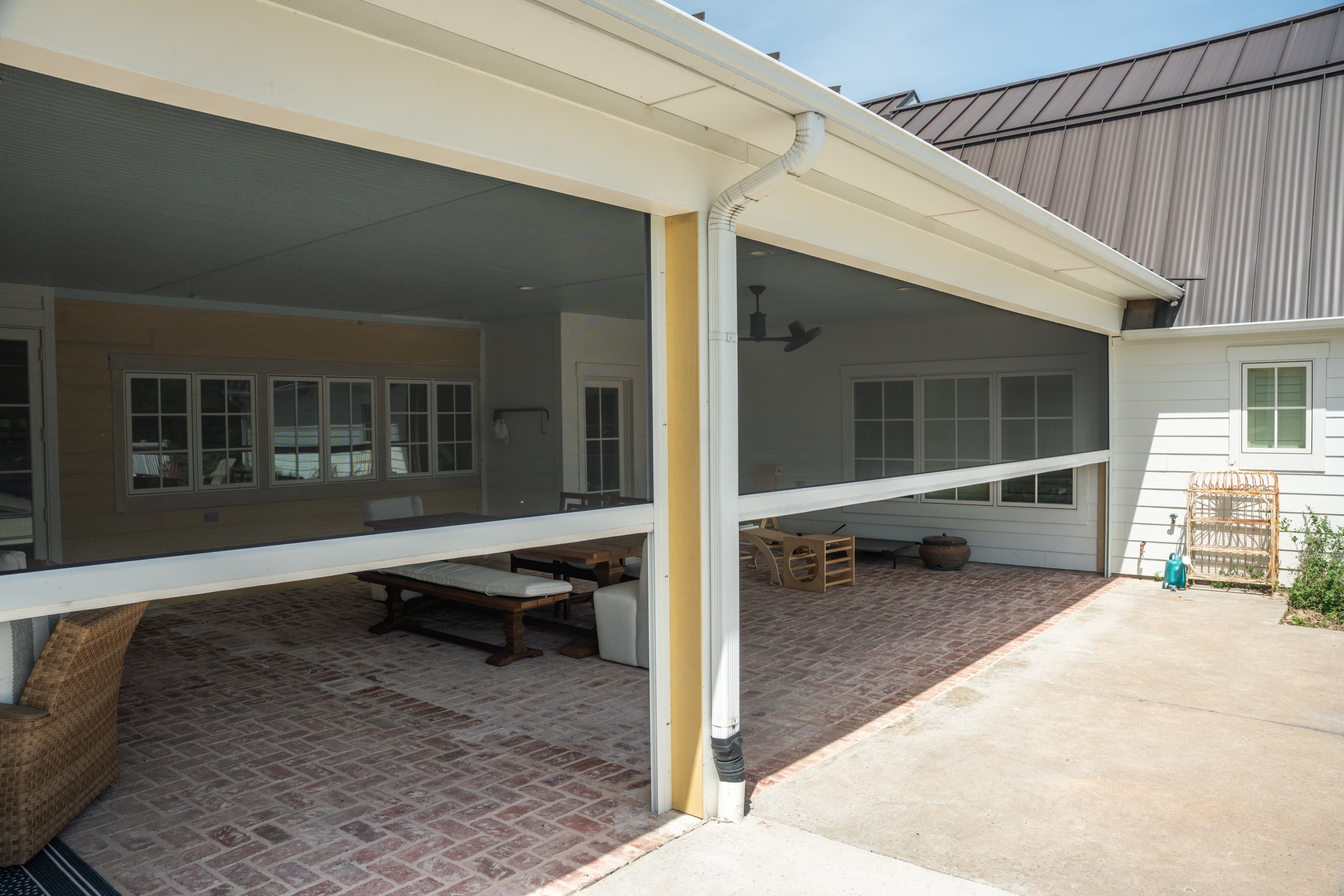 Motorized insect screens with white hardware enclosing a residential covered patio