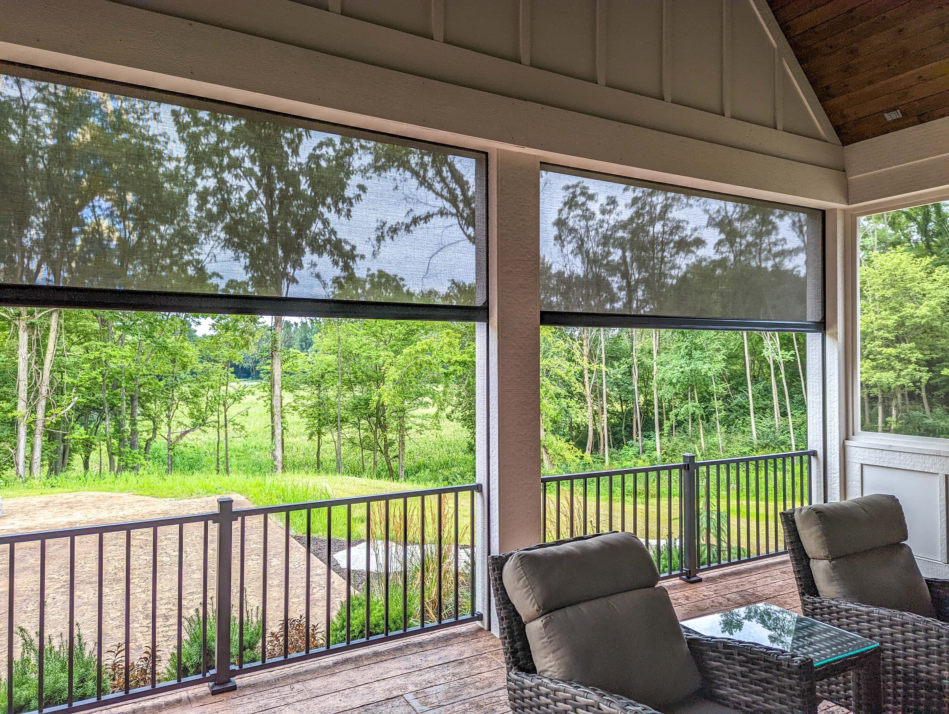 Recessed exterior screens framing a wooded view from a vaulted covered porch seating area